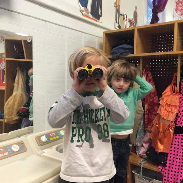 Student in 3 Year Old Program with binoculars