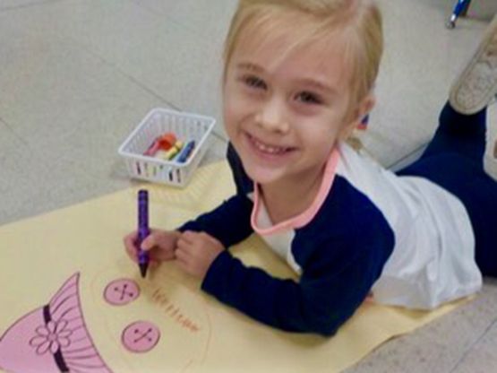 Happy student coloring in 4 Year Old Program